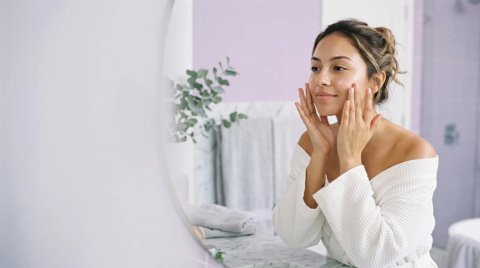Mujer aplicándose crema facial NutriStore frente a un espejo